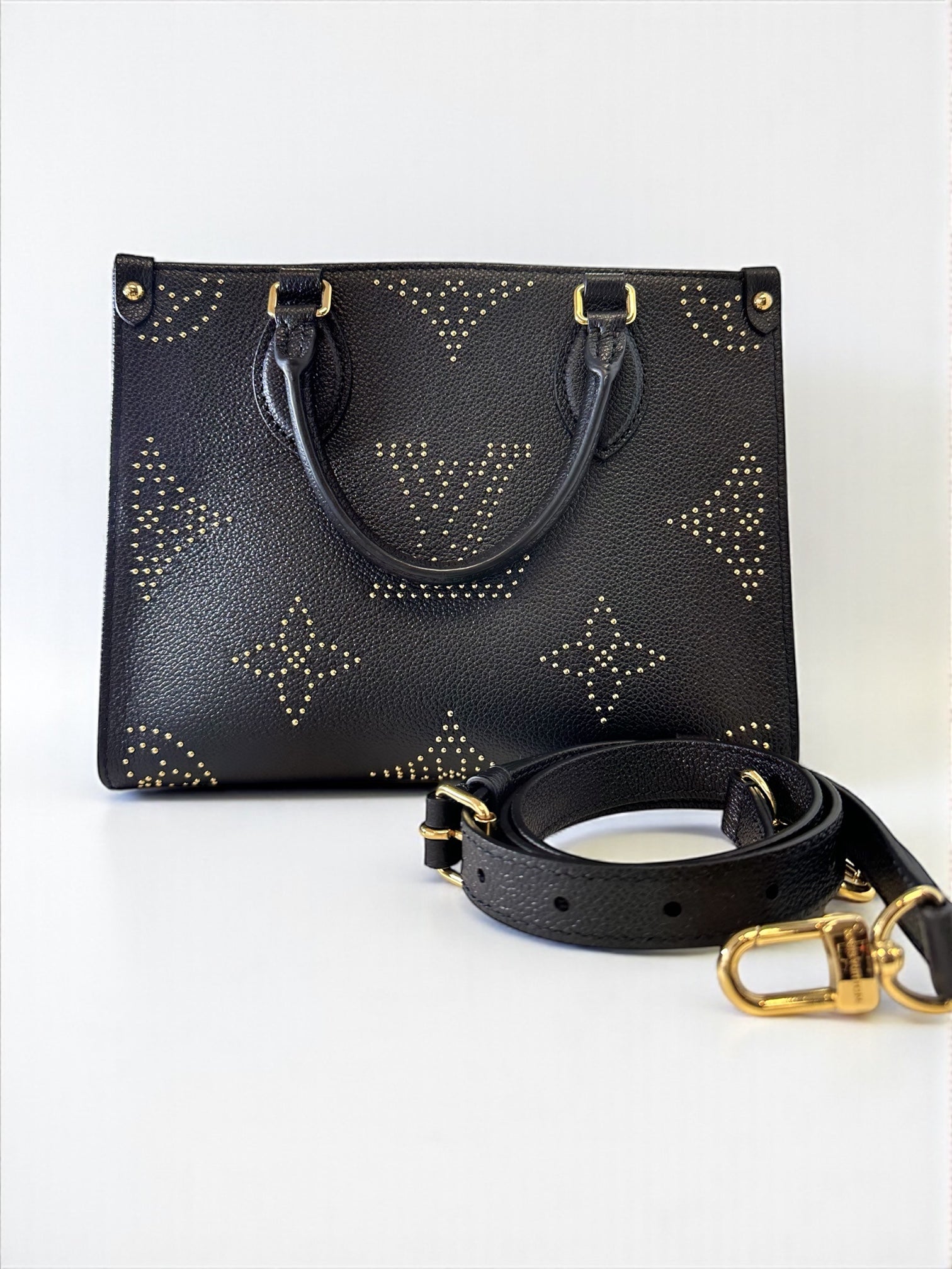 Sac Louis Vuitton OnTheGo PM neuf en cuir Monogram Empreinte noir. Clous dorés, bandoulière ajustable. Authentique & disponible chez Héritage du Luxe.