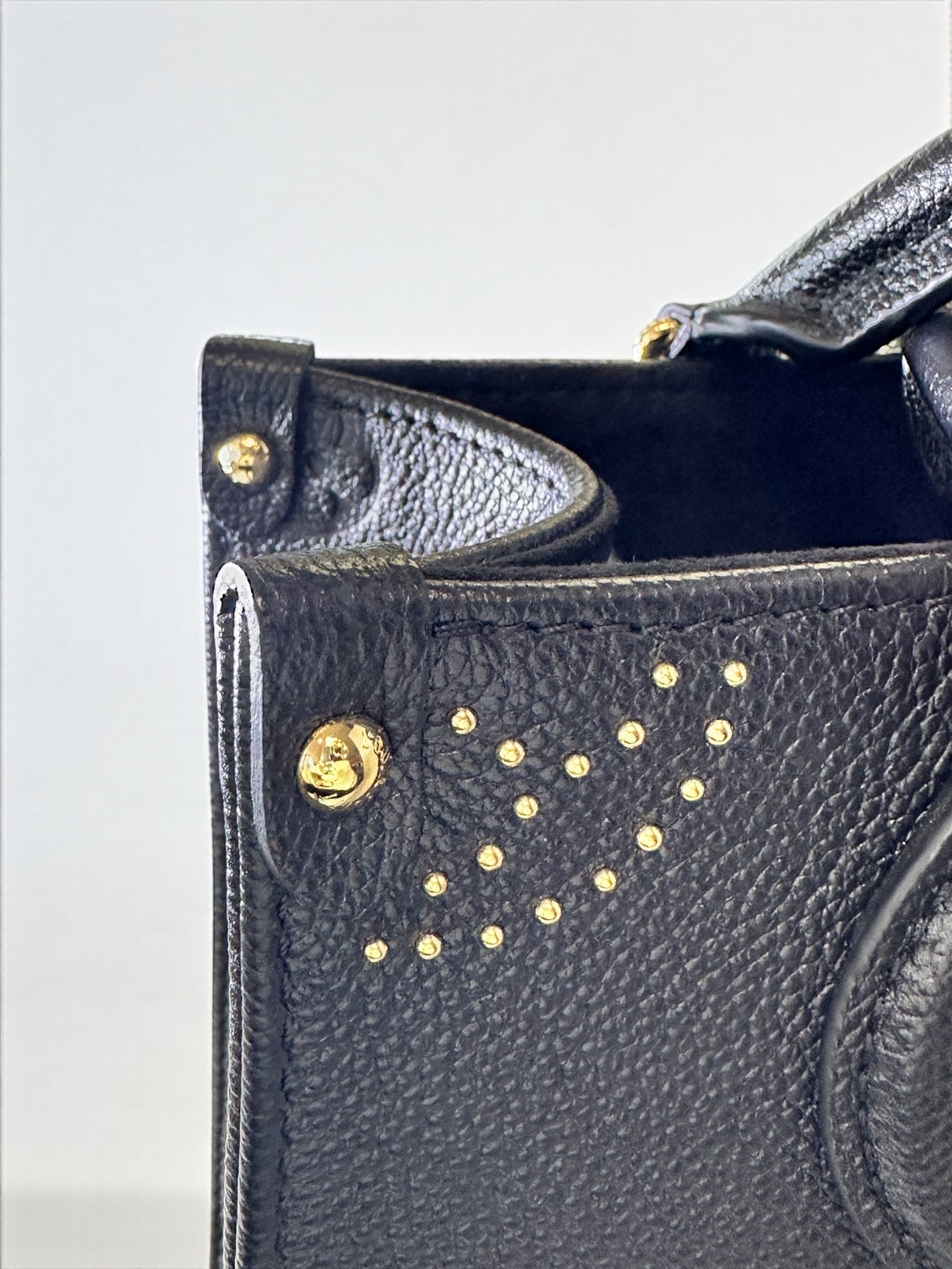 Sac Louis Vuitton OnTheGo PM neuf en cuir Monogram Empreinte noir. Clous dorés, bandoulière ajustable. Authentique & disponible chez Héritage du Luxe.