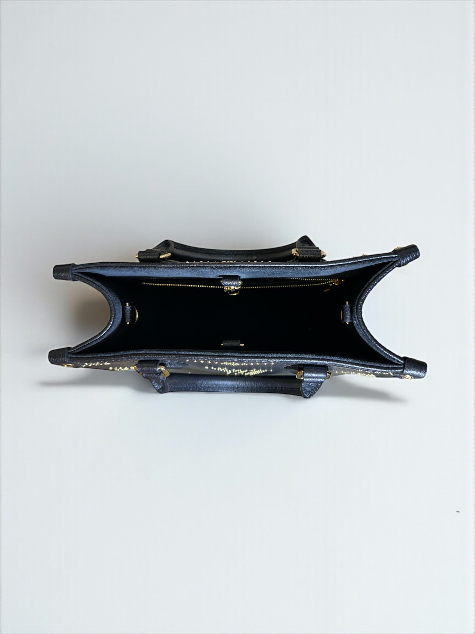 Sac Louis Vuitton OnTheGo PM neuf en cuir Monogram Empreinte noir. Clous dorés, bandoulière ajustable. Authentique & disponible chez Héritage du Luxe.