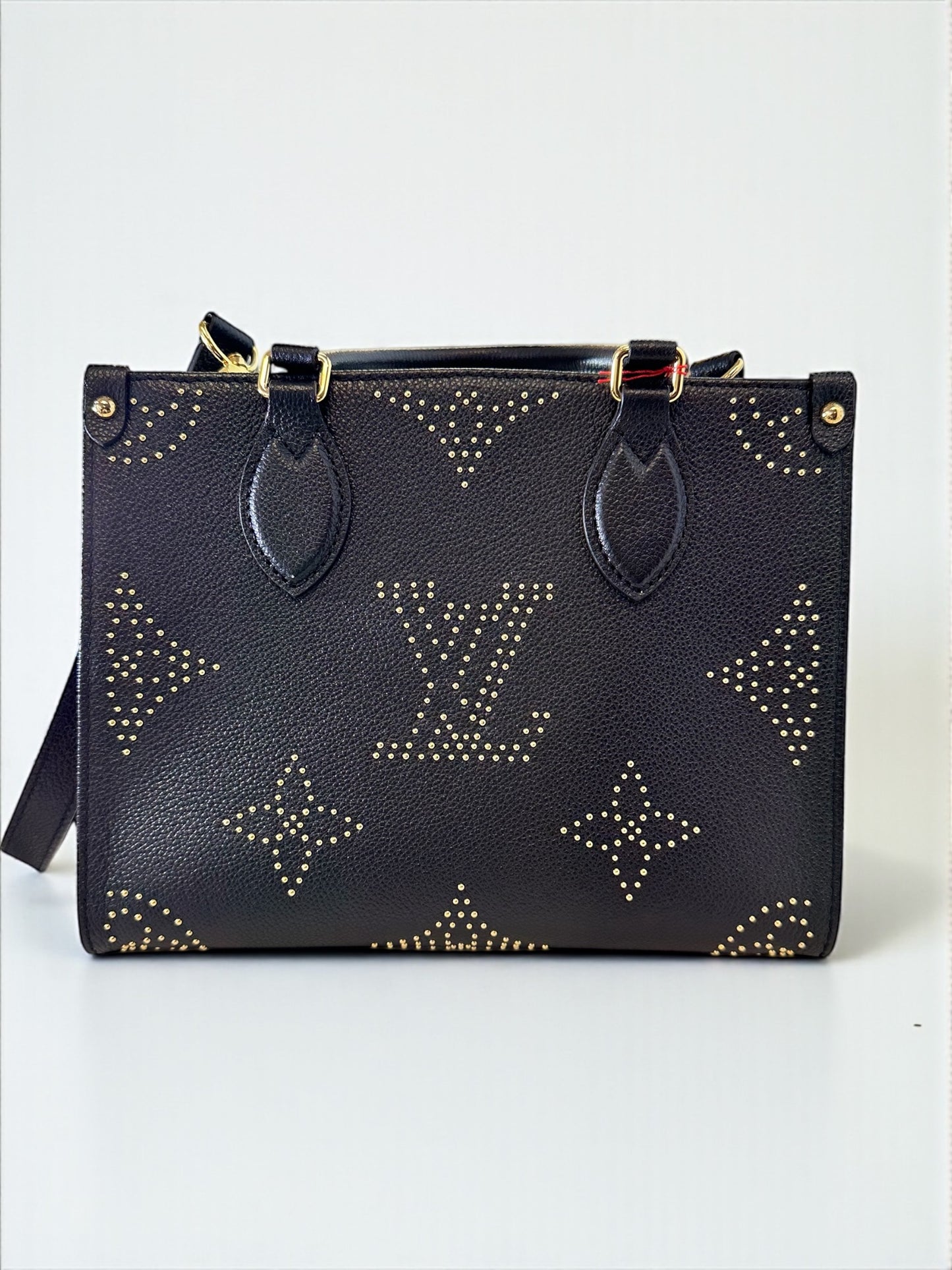 Sac Louis Vuitton OnTheGo PM neuf en cuir Monogram Empreinte noir. Clous dorés, bandoulière ajustable. Authentique & disponible chez Héritage du Luxe.