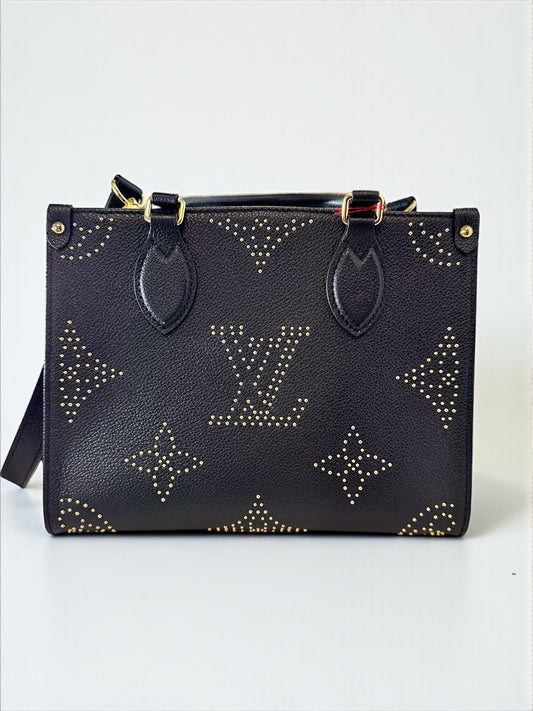 Sac Louis Vuitton OnTheGo PM neuf en cuir Monogram Empreinte noir. Clous dorés, bandoulière ajustable. Authentique & disponible chez Héritage du Luxe.